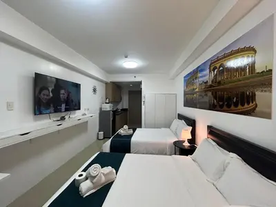 a hotel room with two beds and a flat screen tv at MALL OF ASIA 1156 Affordable Staycation DYNASTEL SHORE in Manila
