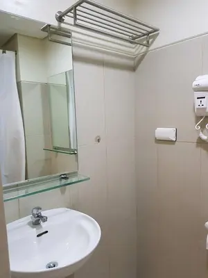 a bathroom with a sink and a mirror at Studio unit at The Breeze Residence in Manila