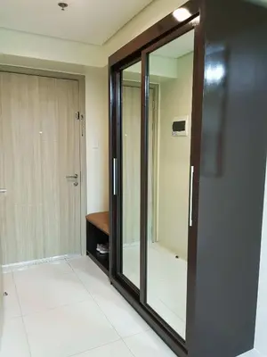 a glass door in a room with a mirror at Studio unit at The Breeze Residence in Manila