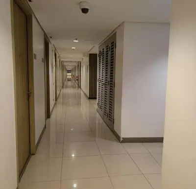 a hallway of a building with white tile floors at DFA ASEANA 1158 DYNASTEL SHORE Staycation in Manila