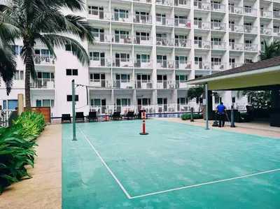 a tennis court in front of a hotel at DFA ASEANA 1158 DYNASTEL SHORE Staycation in Manila
