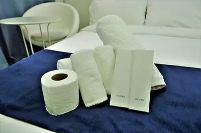 a pile of towels and a roll of toilet paper on a bed at WORLD TRADE CENTER 959 DYNASTEL SHORE Staycation in Manila