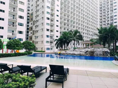 a large swimming pool with chairs and buildings at BAY WALK MANILA 957 DYNASTEL SHORE Staycation in Manila
