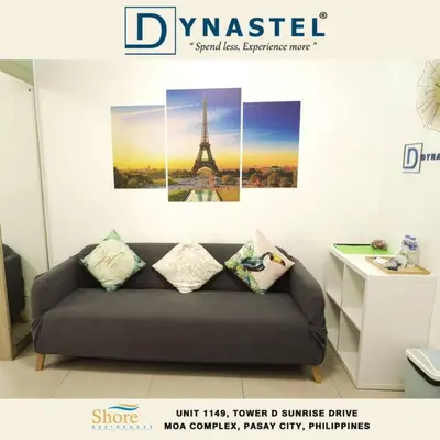 a couch in a room with a picture of the eiffel tower at MALL OF ASIA 1149 DYNASTEL SHORE Staycation in Manila