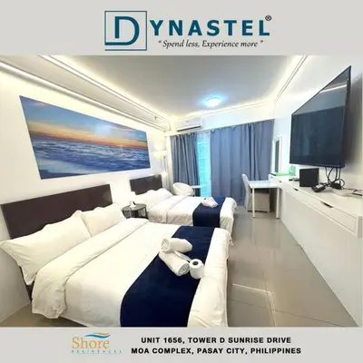 a hotel room with two beds and a flat screen tv at MALL OF ASIA 1656 Dynastel Shore Staycation in Manila