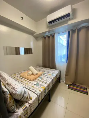 a small bedroom with a bed and a window at Sea Residences MOA Pasay City - Ruffa's Condotel in Manila