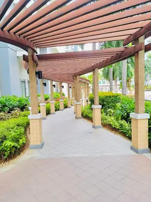 a wooden pergola in front of a building at Condotel Across Naia T3 at ONE PALM TREE VILLA CLUSTER B in Manila