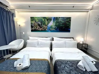 a bedroom with two beds and a painting on the wall at DYNASTEL SHORE 635 MOA Pasay Staycation in Manila