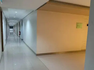 an empty hallway in a building with a yellow wall at DYNASTEL SHORE 635 MOA Pasay Staycation in Manila