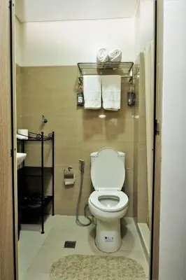 a bathroom with a toilet with towels on the wall at SHORE RESIDENCES HOTEL Staycation 621 Dynastel in Manila