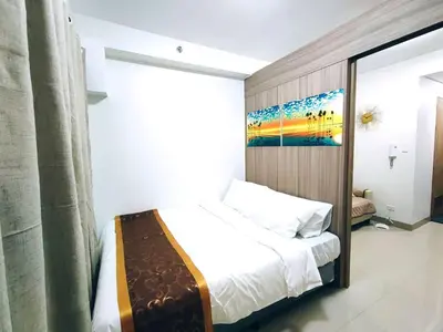 a bedroom with a bed and a painting on the wall at DYNASTEL 787 SHORE Staycation in Manila