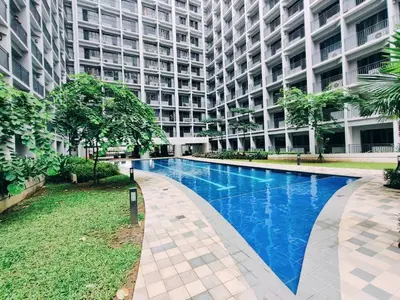 a large building with a swimming pool in front of it at Pasay MOA 1486 Dynastel Shore Staycation in Manila