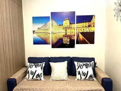 a room with a couch with four paintings on the wall at Shore Residences 1576 Dynastel Staycation in Manila
