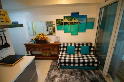 a living room with a couch and a mirror at Cozy Chic Condotel Azure Urban Resort Residences in Manila