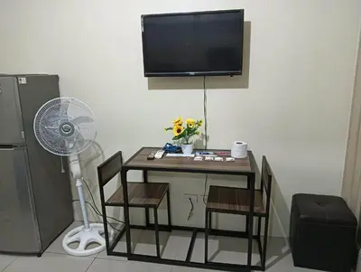 a room with a table with chairs and a fan at MOA Condo by Ashti in Manila