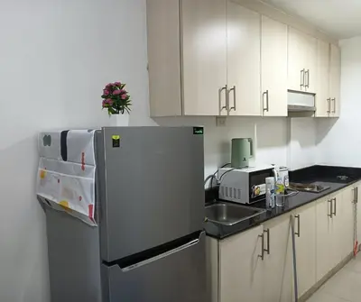 a kitchen with a refrigerator and a sink at MOA Condo by Ashti in Manila