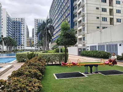 a person standing in a playground in a city at MOA Condo by Ashti in Manila