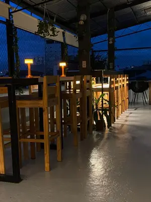 a row of wooden tables and chairs with lights on them at Lime Lite Manila Hostel in Manila