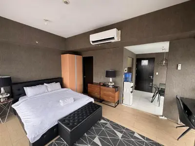 a bedroom with a bed and a room with a television at Modern Studio at NAIA Terminal 3 in Manila