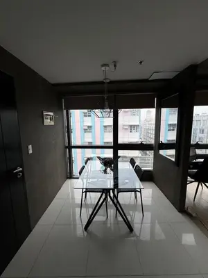 a table and chairs in a room with a large window at Modern Studio at NAIA Terminal 3 in Manila
