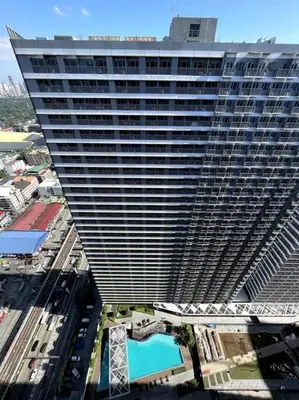 an overhead view of a tall building with a pool at cozy studio unit at fame residence metro manila in Manila