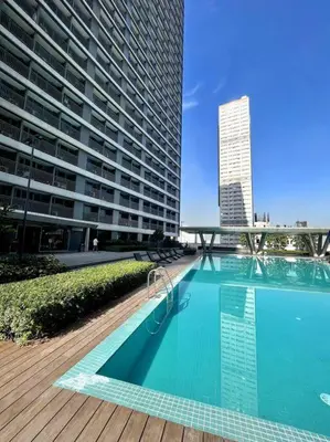 a large swimming pool in front of a tall building at cozy studio unit at fame residence metro manila in Manila