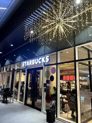 a store with a starbucks sign on the side of a building at cozy studio unit at fame residence metro manila in Manila