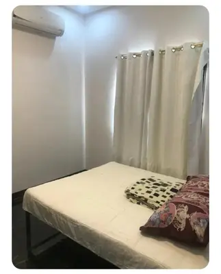 a small room with a bed with a curtain at Kame House in Bacoor