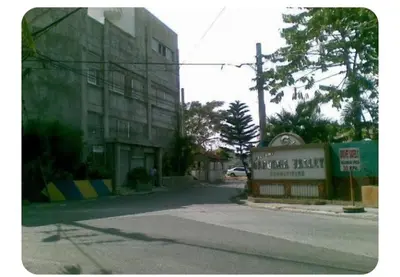 a building on a street with a sign in front at Kame House in Bacoor