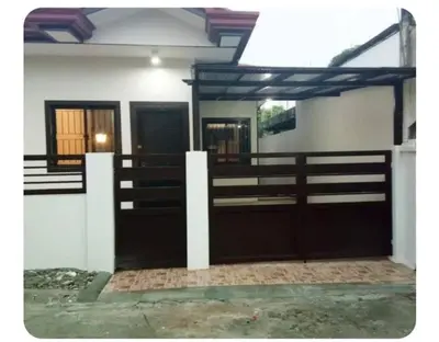 a stable with two doors and a fence at Kame House in Bacoor