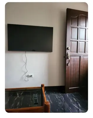 a room with a flat screen tv and a door at Kame House in Bacoor