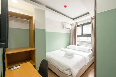 a small bedroom with a bed and a table at St. Marvin Studio Makati M402 in Manila