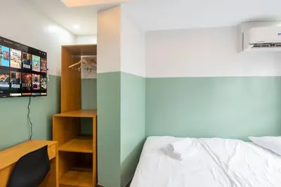 a bedroom with a bed and a tv on a wall at St. Marvin Studio Makati M402 in Manila