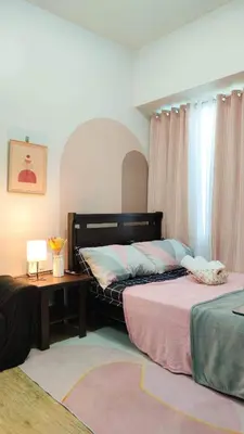 a bedroom with two beds and a table with a lamp at anuva residences room 1 in Manila