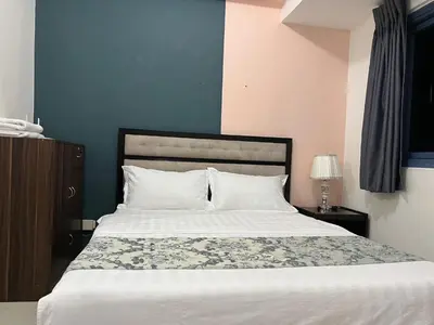 a bedroom with a large bed with white sheets at GRAND RIEVERA SUiTES in Manila