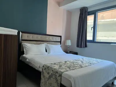 a bedroom with a large bed with white sheets and a window at GRAND RIEVERA SUiTES in Manila