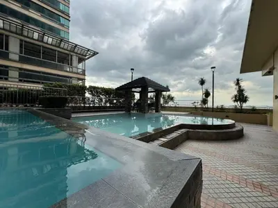 a swimming pool with a gazebo next to a building at GRAND RIEVERA SUiTES in Manila