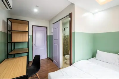a bedroom with a bed and a desk and a toilet at St. Marvin Studio Makati M408 in Manila