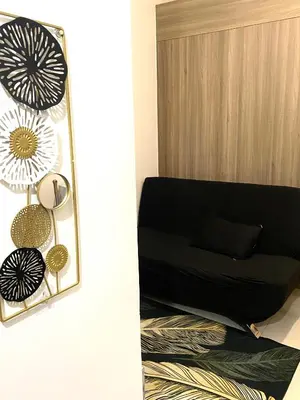 a mirror on a wall next to a black couch at aesthetic suite in edsa smdc fame VERY FAST WIFI in Manila