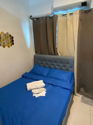 a bedroom with a blue bed with towels on it at aesthetic suite in edsa smdc fame VERY FAST WIFI in Manila