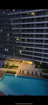 a view of a large building with a swimming pool at aesthetic suite in edsa smdc fame VERY FAST WIFI in Manila