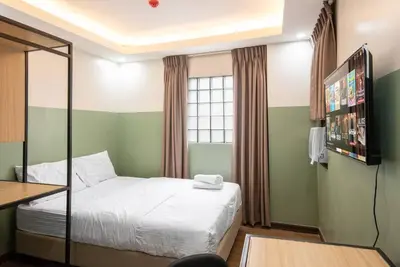 a small bedroom with a bed and a television at St. Marvin Studio Makati M409 in Manila