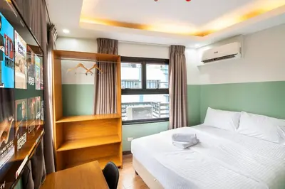 a bedroom with a bed and a desk and a window at St. Marvin Studio Makati M405 in Manila