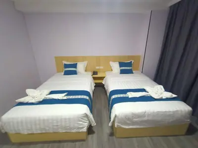 two beds in a hotel room with white and blue sheets at Venice Star Grand Hotel in Manila