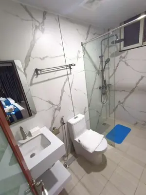 a bathroom with a toilet and a shower and a sink at Venice Star Grand Hotel in Manila