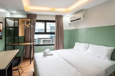 a bedroom with a bed and a desk and a window at St. Marvin Studio Makati M403 in Manila