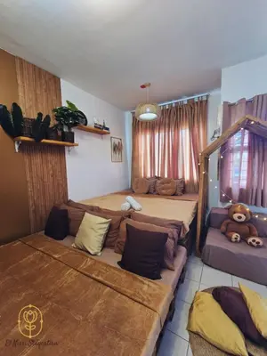 a bedroom with two beds and a couch at El Nissi Staycation, FAMILY CABIN, CONTEMPORARY CABIN, Enchanted Kingdom in Santa Rosa