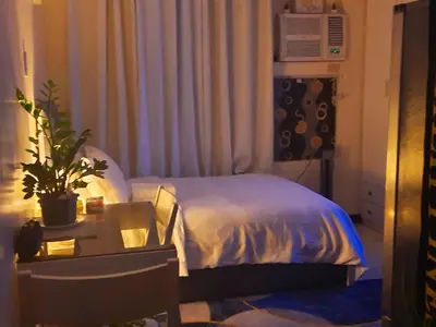 a bedroom with a bed and a desk with a plant at Cozy Corner Haven near Venice Grand Canal Mall in Manila