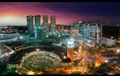 a city skyline at night with a clock tower at Cozy Corner Haven near Venice Grand Canal Mall in Manila