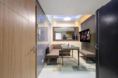 a room with a table and chairs and a mirror at Lush Residences Makati in Manila